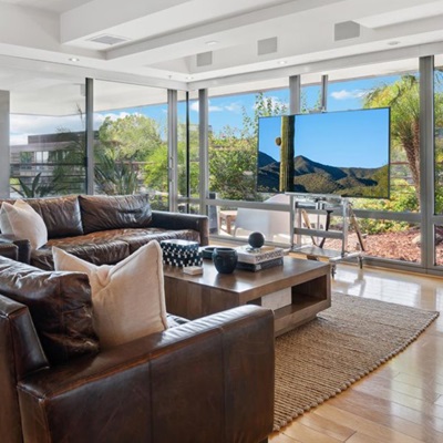 A couch and flatscreen TV adorn a luxury condo's living room.