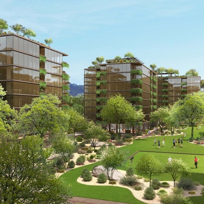 A daytime rendering of Optima McDowell Mountain Village, showcasing glass-fronted buildings surrounded by lush greenery and landscaped lawns. Groups of people enjoy open spaces in the courtyard, framed by trees and desert plants.
