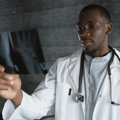 Doctor in a white lab coat examining an x-ray in a modern office.