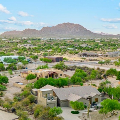 Aerial view of Greater Phoenix neighborhood with desert landscape and mountain backdrop.