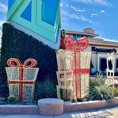 Large red and gold decorative gift boxes displayed near the Scottsdale Spire and Maggiano’s restaurant.