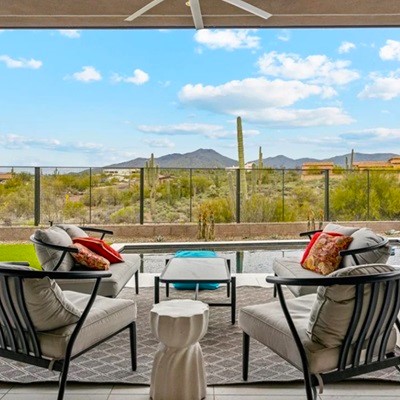 Outdoor patio area with cozy seating and scenic desert mountain views at a Scottsdale home.