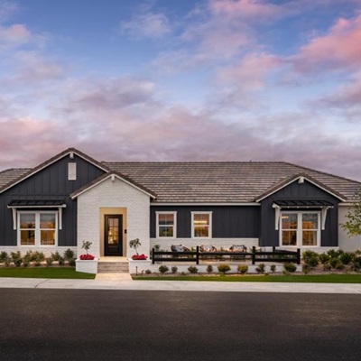 Modern farmhouse-style home with dark siding and white brick accents at Sterling Grove in Surprise, AZ.