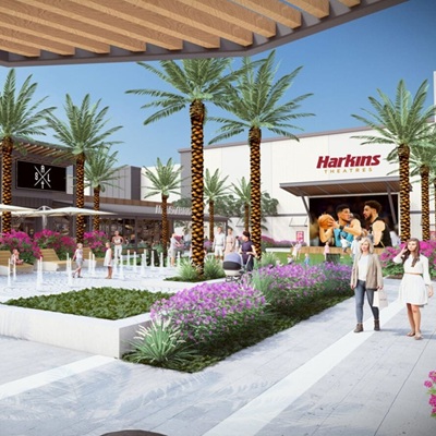 A conceptual rendering of a lively outdoor plaza in Verrado with palm trees, colorful landscaping, seating areas, and a Harkins Theatres building, creating a lively community space.