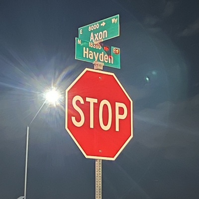 Photo of a two street signs saying Axon and Hayden as well as a stop sign below them.