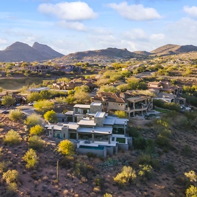 Scenic desert landscape with luxury homes nestled among rolling hills and mountain views.