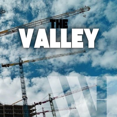 Photo of construction cranes and puffy clouds with the words "The Valley" over top the photo.