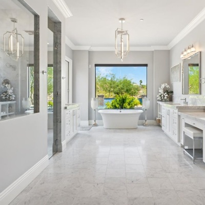 An elegant bathroom showcases a freestanding tub, dual vanities, and a large walk-in shower.