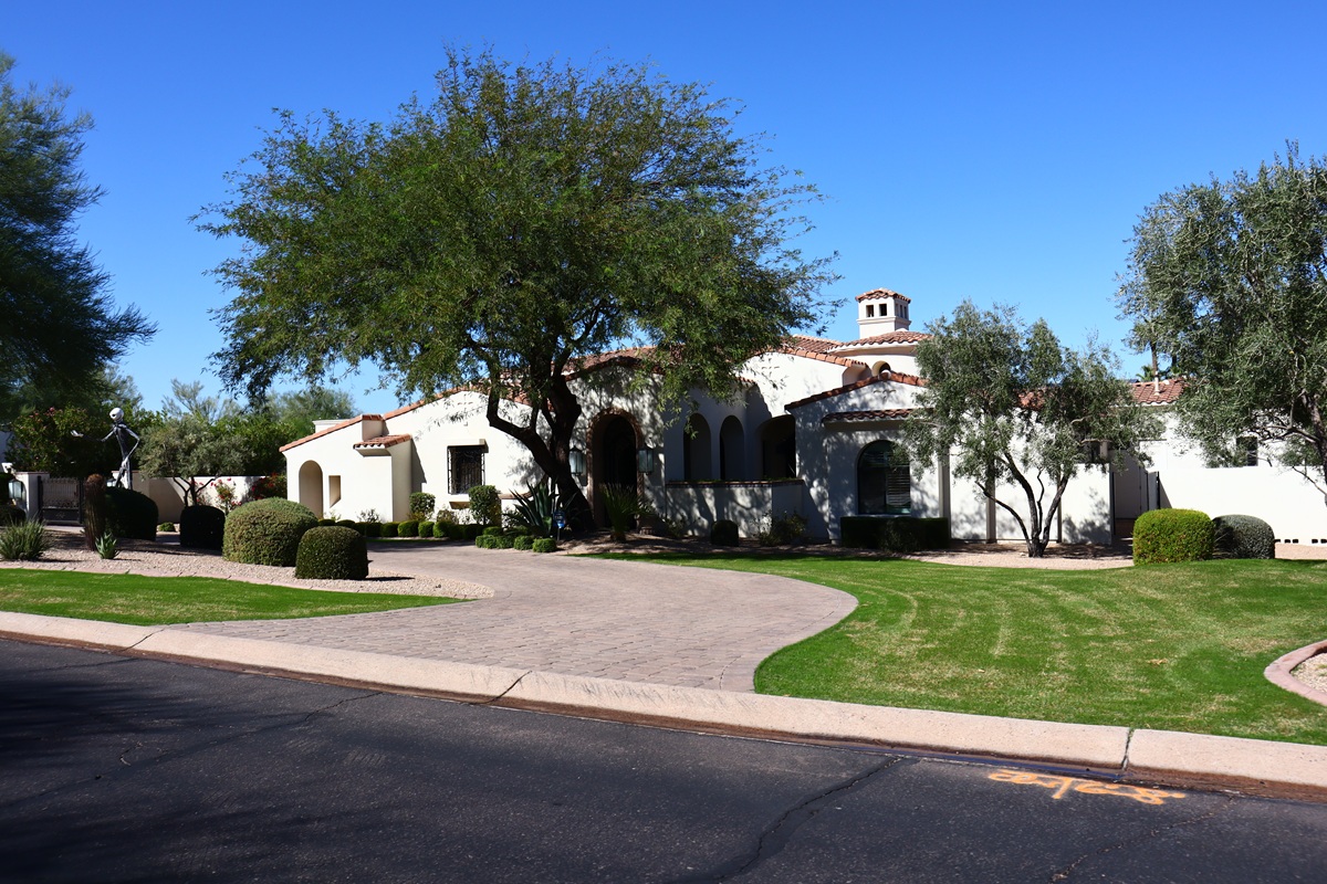 Stylish southwestern-style home with lush greenery and a manicured front yard.