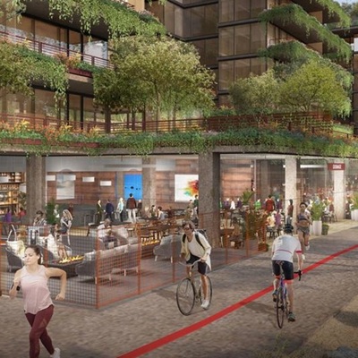 Rendering of Optima McDowell Mountain showing a vibrant mixed-use development with modern glass buildings adorned with lush greenery on balconies and rooftops. The street level features active retail and dining spaces with people walking, biking, and socializing along a landscaped pedestrian and bike path.