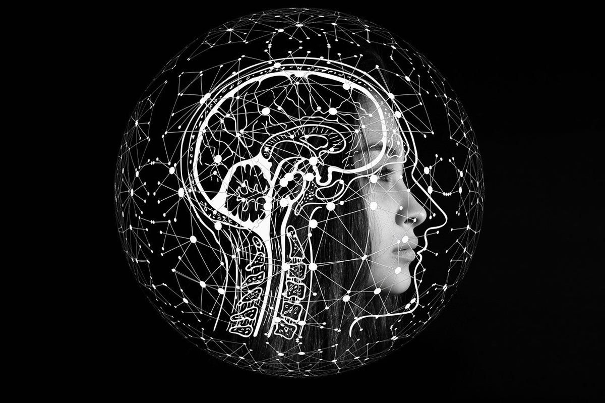 Silhouette of a woman’s profile overlaid with a white anatomical brain diagram and a network of glowing connections.