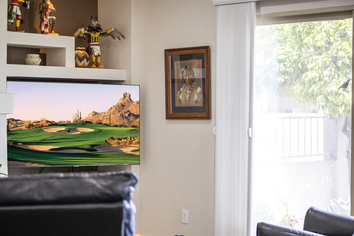 Living room with desert-themed decor and golf scene on TV.