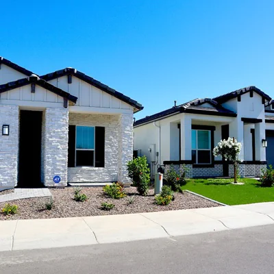 Photo of two new homes with a bright blue sky behind them.