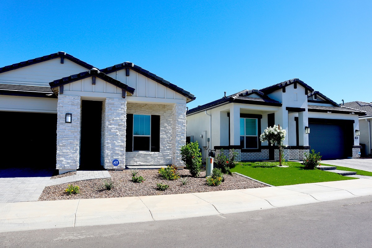 Photo of two new homes with a bright blue sky behind them.